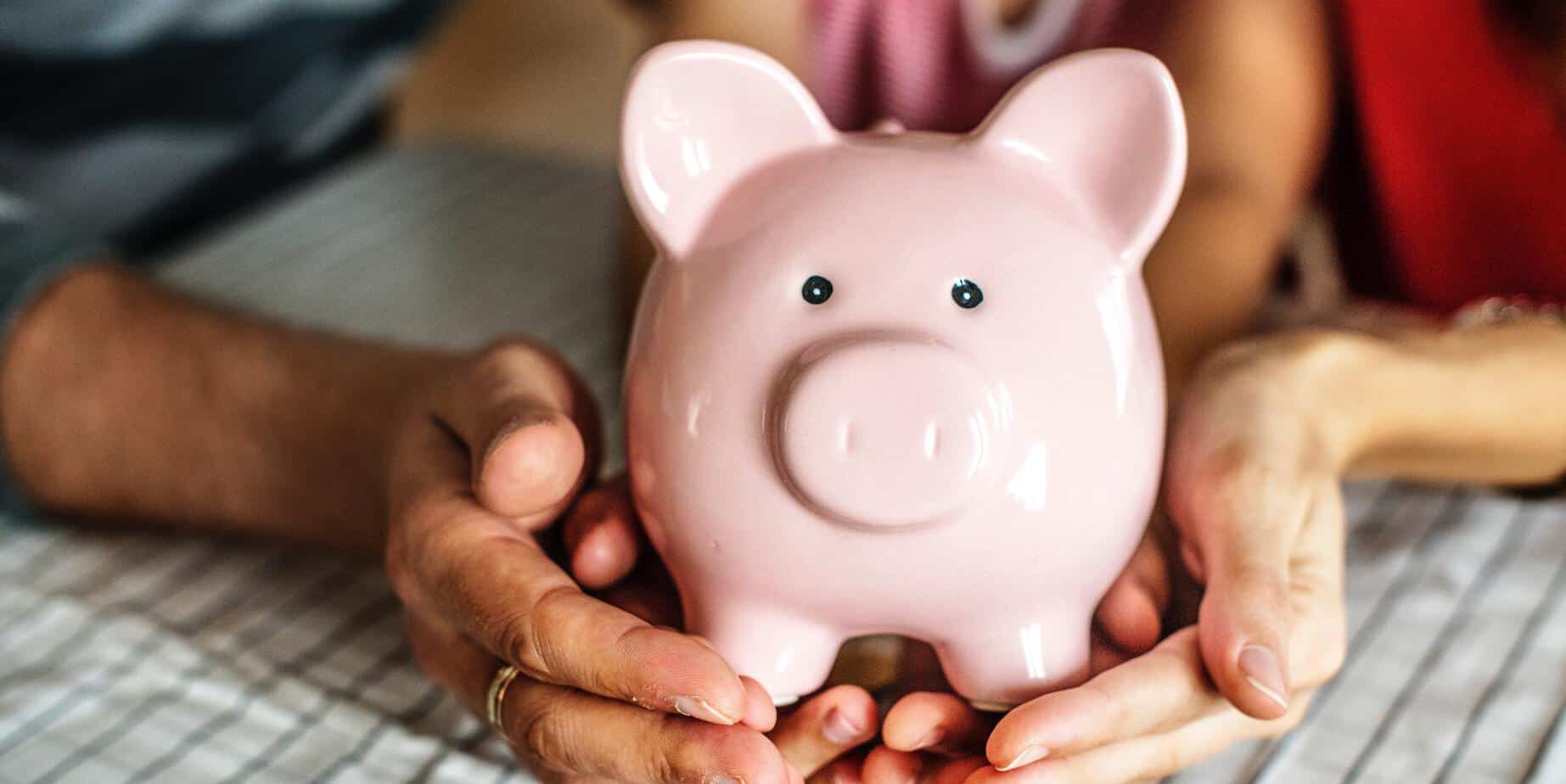 Picture of piggy bank being held by different ages of hands - Photo by rawpixel.com from Pexels