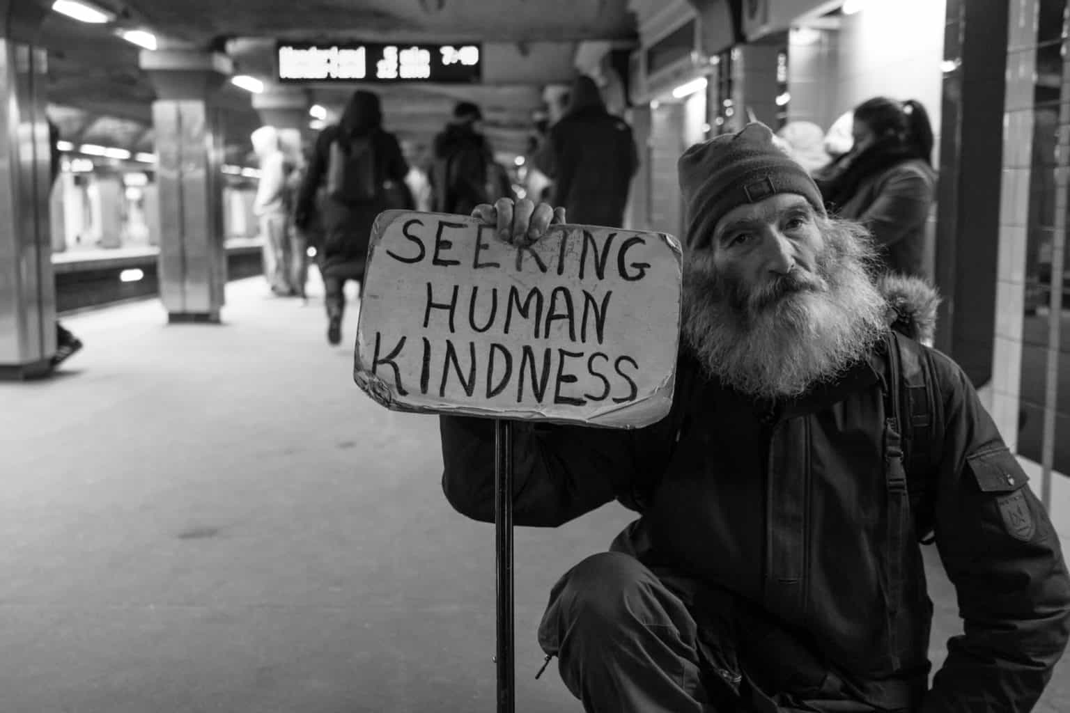https://breakyourboundaries.tv/seeking-human-kindness-print - Prints Available - 25 % proceeds goes to supporting homelessness - I met Michael in a Boston subway station. I told him I liked his sign. “What matters is what it means to you,” he told me.I asked what it meant to him. “Doing a deed or expressing kindness to another person without expecting anything in return,” Michael said.I love approaching strangers wherever I go. Listening and talking to them teaches you about people and how similar we all are to one another. Just like Michael, we’re all seeking human kindness.