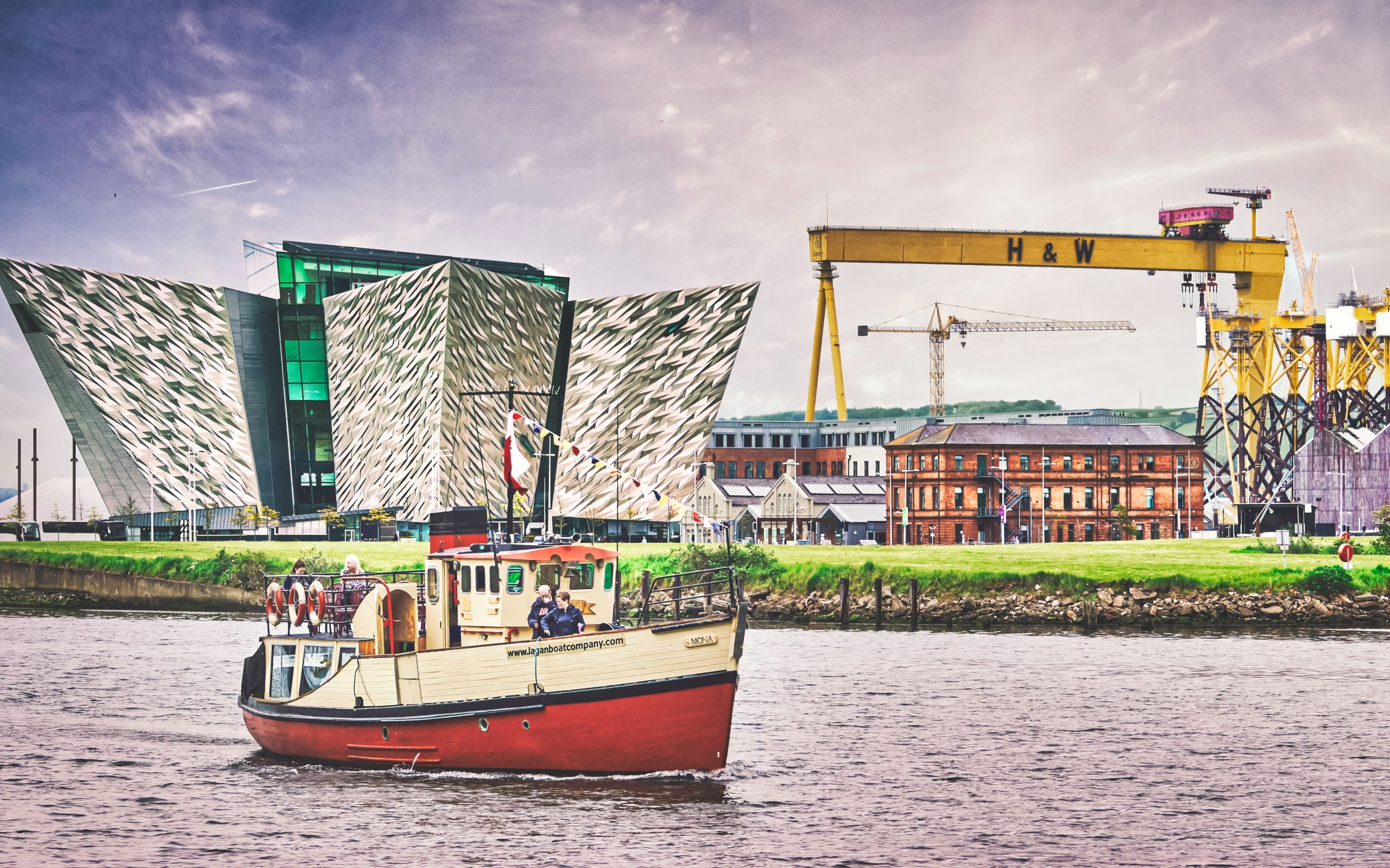 Three Belfast landmarks in one shot. From left to right: Titanic Belfast, a museum for all things Titanic related; the very large Harland and Wolffe ship building crane Goliath; and immediately below it, the red bricked building where the Titanic was designed by Harland and Wolff prior to its fateful end in 1912 (May, 2019).