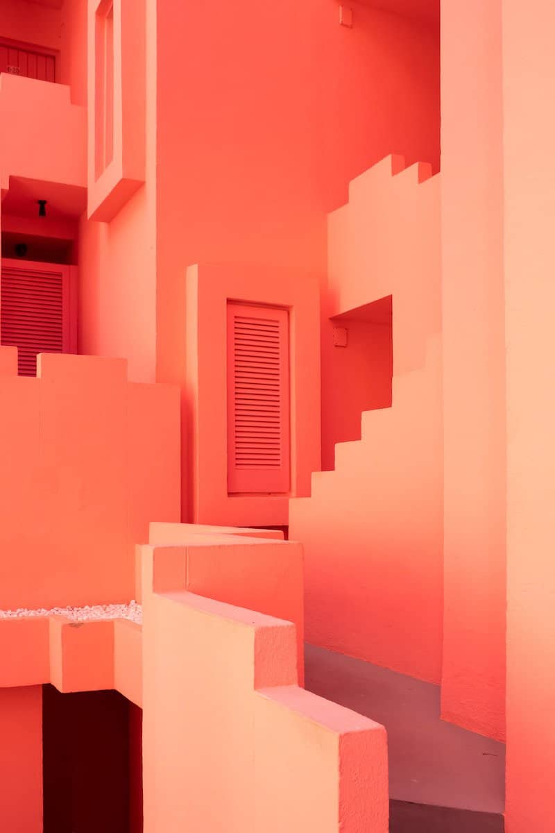 a pink building with stairs and a door
